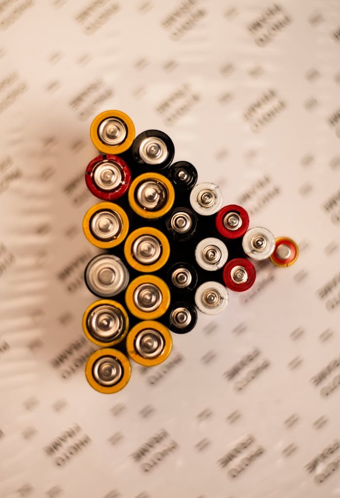 our-services-2 Top view of assorted batteries in an artistic arrangement on a printed surface.