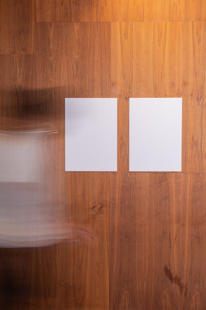 our-services-3 Faceless blurred person in motion strolling along wooden wall with creative rectangular white blank posters in light room in studio